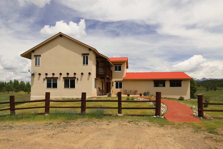 Piedra Pines Lodge on its meadow with the San Juan Mountains behind