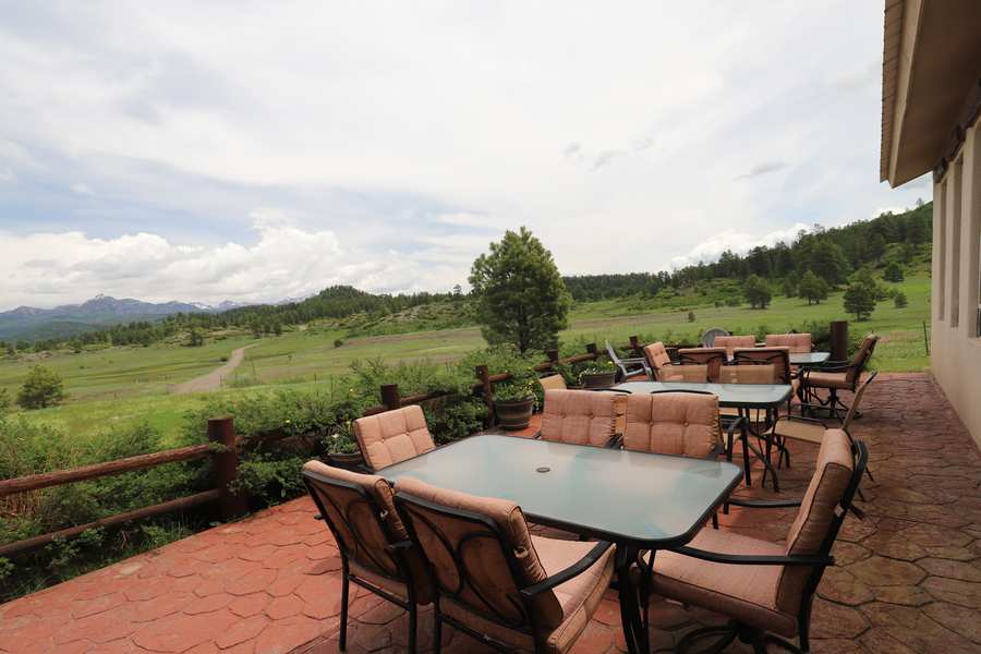 Patio dining tables looking out over the meadow and distant mountains