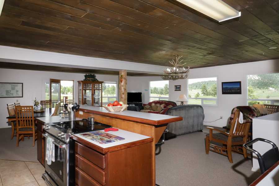 Open kitchen island looking into the main living room and windows onto the valley