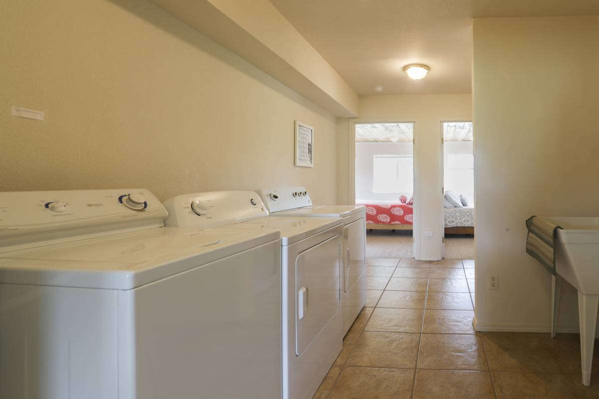 Laundry room with a washer and two dryers